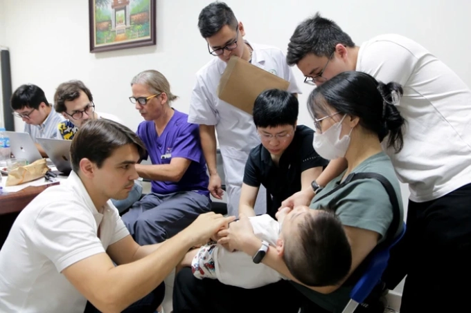 Vietnamese and international experts examine a boy with birth defect at the Saint Paul General Hospital. Photo: Thuy Duong